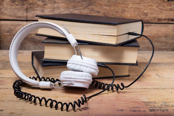 Pile de livres avec un casque audio "branché" entre deux pages